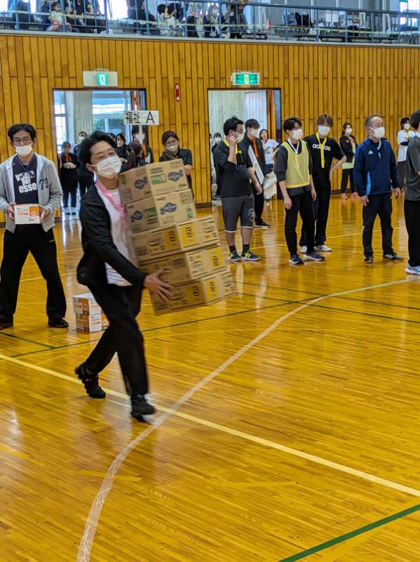 宅配リレーでは段ボールの持ち方に気を付けながら次の走者につなぎます。